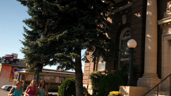 women walking on a sidewalk with shopping bags
